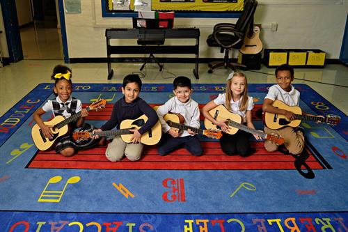 students holding guitars 